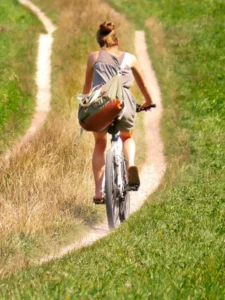 lady cycling in the mud road.